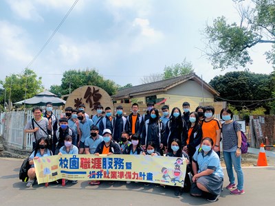 公明國中於光復新村招牌前大合照.jpg